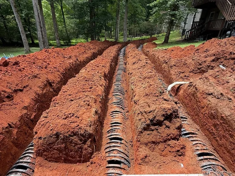 SepticRooter truck and equipment staged at a septic replacement job site