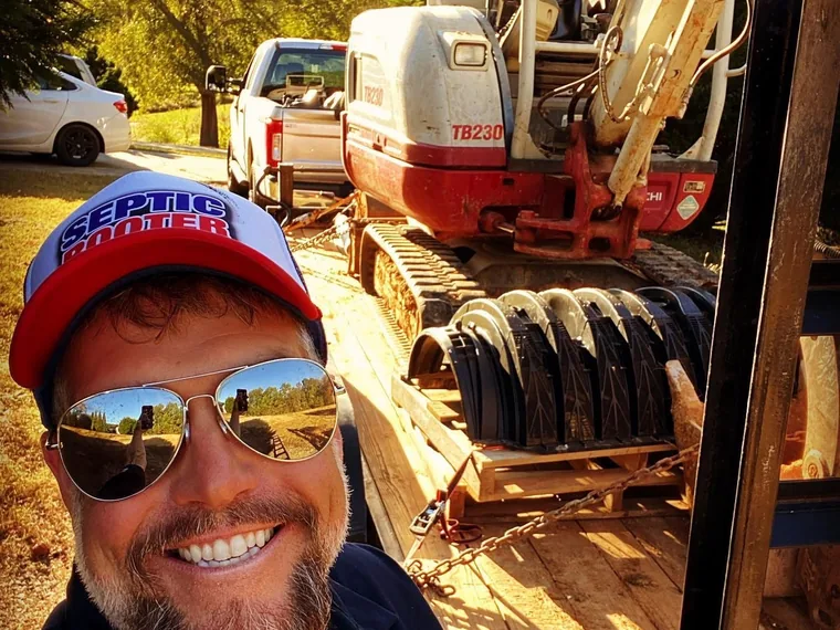 SepticRooter owner with an excavator loaded on a trailer
