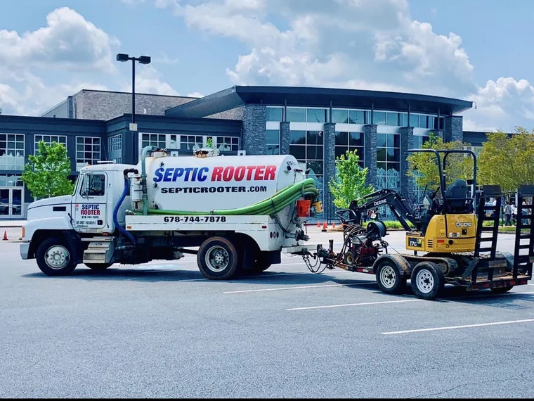 SepticRooter pump truck and John Deere mini-excavator in a parking lot