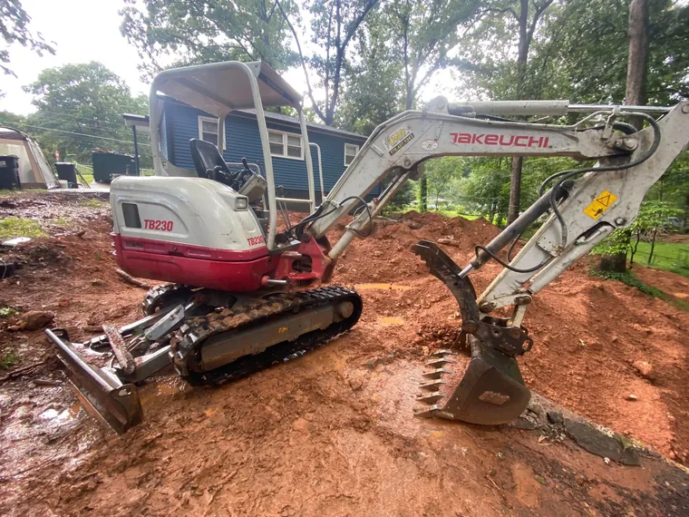 Takeuchi mini-excavator on site at a residential septic repair